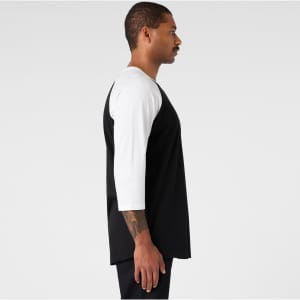 A black and white raglan t-shirt featuring three-quarter length sleeves and a logo on the chest.