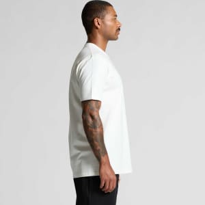A white organic t-shirt displayed on a model, featuring a logo, with a side view showcasing its relaxed fit.