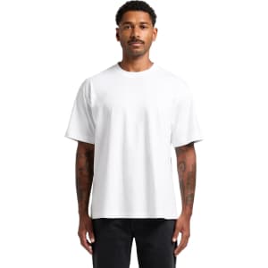 A white Box Tee, featuring a relaxed fit and short sleeves, displayed on a model with tattoos.