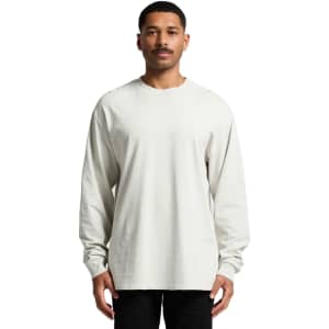 A long-sleeve tee in a faded cream colour, featuring a relaxed fit and a logo on the front.