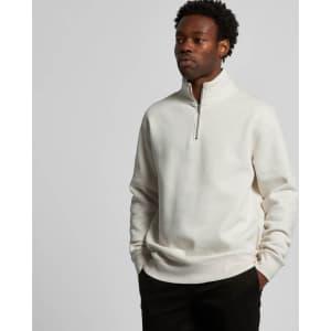 A cream Stencil Half Zip Crew jumper featuring a high collar and a zip closure, worn by a model.