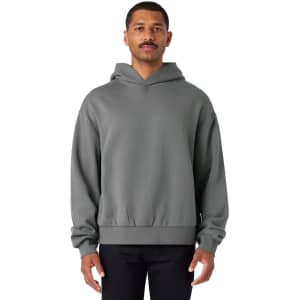 A grey hoodie with a front pocket and a logo, featuring an elasticated hem and oversized silhouette.