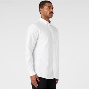 A white button-up Oxford shirt displayed on a male model, featuring a logo on the chest.