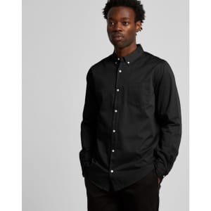 A black denim wash shirt with a button-up front and a chest pocket, worn by a model.