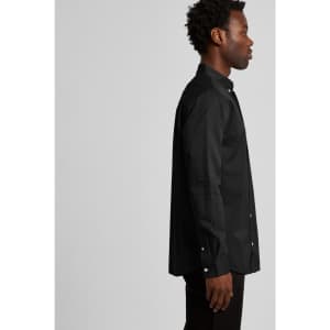 A black button-up denim wash shirt displayed on a male model from the side, featuring a collar and long sleeves.