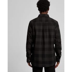 A black check button-up shirt with a solid back and long sleeves. The shirt features a classic collar and a logo.