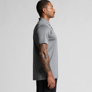 A grey polo shirt worn by a man, featuring short sleeves and a collar, with a visible logo on the chest.