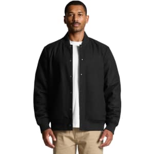 A black felt bomber jacket is worn by a man, featuring a button-up front and ribbed cuffs. It has a logo on the front.