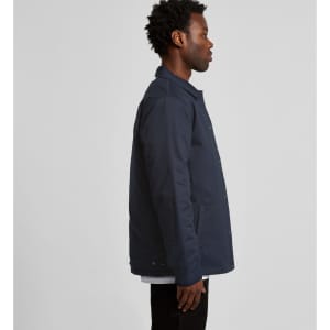 A navy work jacket displayed on a model from the side, featuring a logo on the fabric.