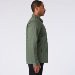 A green service jacket is displayed, featuring a side profile view and a simple design. It has pockets and a collar.