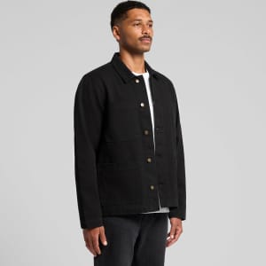 A black canvas chore jacket featuring multiple pockets and a button-up front, displayed on a model.