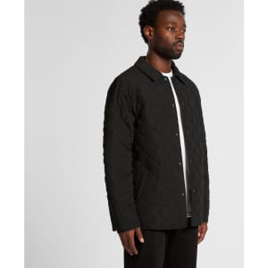 A black quilted puffer jacket with a button-up front, displayed on a model from the side.