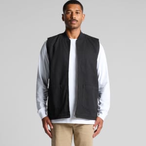 A man wearing a black canvas heavy vest, featuring a zip front and two front pockets, against a neutral backdrop.