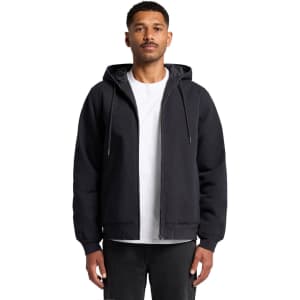 A black canvas bomber hood jacket featuring a front zipper and drawstring hood, worn by a model.