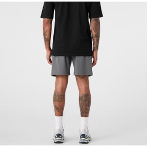 Active shorts in grey, featuring a loose fit and side panels, worn by a person from the back.