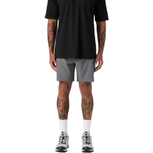 Active shorts in grey, paired with a black shirt and athletic shoes, featuring a logo on the shorts.