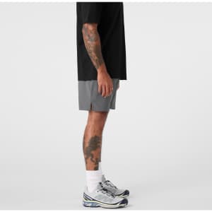 Active shorts in grey, featuring a side view with a black t-shirt and athletic shoes, complete with a logo.