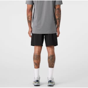 Active Pro Shorts in black, featuring a logo, worn by a person with tattoos, seen from the back.