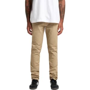 Khaki standard pants displayed on a person wearing a white shirt and black shoes. The image has a logo on the pants.