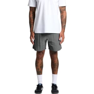 A pair of grey swim shorts with a loose fit, featuring an elastic waistband and a logo detail.