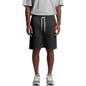Black sports shorts with an elastic waistband and drawstring, modelled by a person wearing a grey t-shirt and shoes.