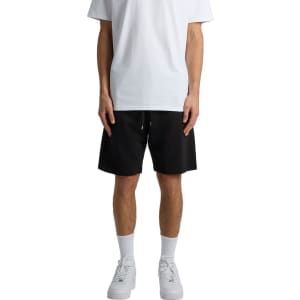 Black sports shorts with an elastic waistband, displayed on a model wearing a white t-shirt and white sneakers.