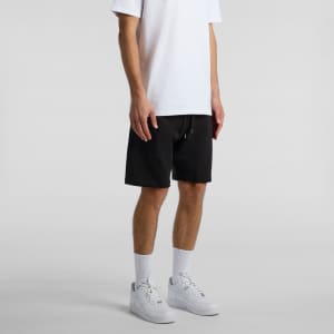 Black sports shorts with a drawstring, featuring a logo, worn with a white T-shirt and white sneakers.