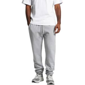 Grey track pants with a relaxed fit, featuring an elastic waistband and cuffs, paired with a plain white t-shirt.