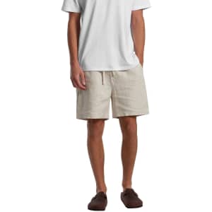 Linen shorts in a light beige colour, featuring a drawstring waist and an accompanying logo.