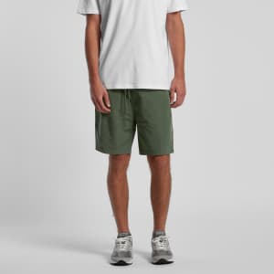 Active training shorts in olive green, featuring an elastic waistband and a logo. Worn with a white t-shirt and trainers.