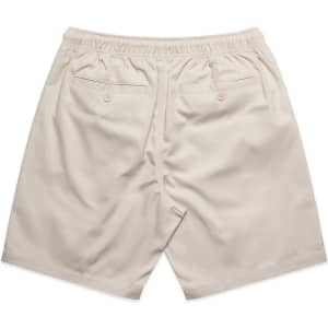 A pair of beige dress shorts with an elastic waistband and two back pockets, featuring a branding logo.