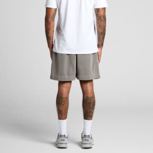 Faded grey track shorts with an elastic waistband, featuring a logo, worn by a person from the back.