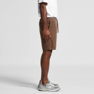A pair of brown dress shorts featuring an elastic waistband and side pockets, worn with grey sneakers.