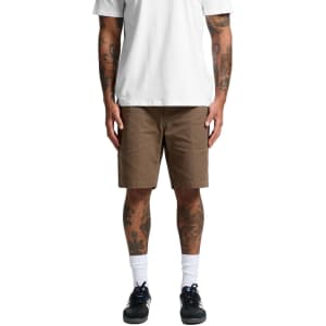 Cotton cargo shorts in a light brown colour, featuring multiple pockets, worn by a person with tattoos.