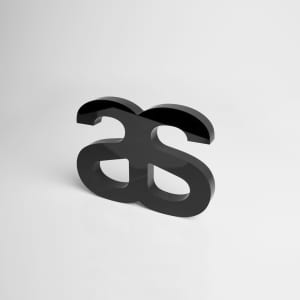 A black acrylic plaque featuring a stylised logo design, showcasing a modern, sleek look.