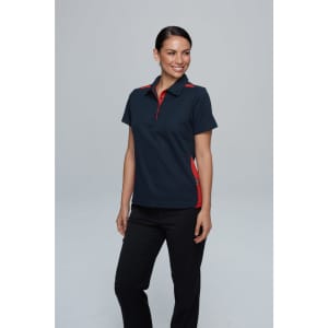 A navy polo shirt with red accents, featuring a collar and side panels, worn by a smiling woman. 