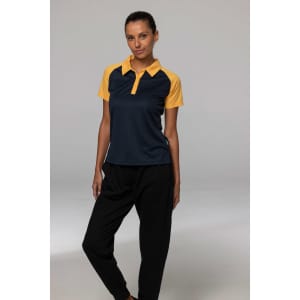 A polo shirt in navy blue with yellow sleeves, featuring a logo. Model wearing it with black pants.