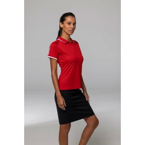 A red polo shirt with white detailing, modelled by a woman, paired with a black skirt. The shirt features a logo.