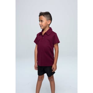 A maroon kids' polo shirt displayed on a smiling child, paired with black shorts. The shirt features a collar and a logo.