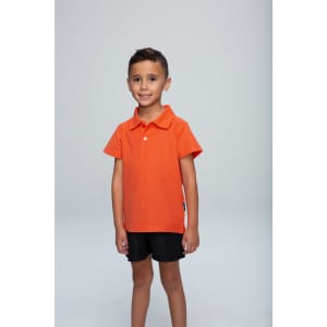 An orange polo shirt for kids, featuring a collar and a logo, worn by a smiling child against a plain background.