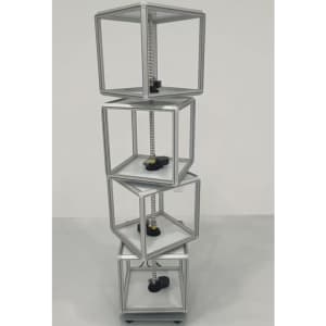 A rotating light box with transparent compartments, featuring a silver frame and black bases, designed for exhibitions and events.