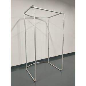A silver tension fabric change room frame with a rectangular base and open top, set against a plain wall.