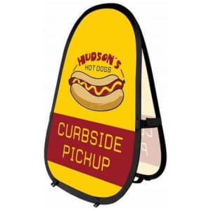 A vertical pop-up banner featuring a yellow background with a hot dog graphic and curbside pickup text. It has a logo.