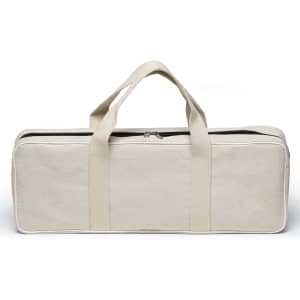 A beige carrying bag with handles and a zippered closure, featuring contrasting white stitching.