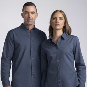 A women's button-up shirt in navy blue, featuring a collar and a logo, modelled by a woman.