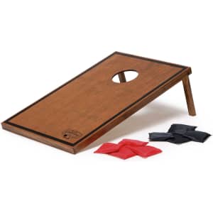 A wooden cornhole board with a hole and four red and four black bean bags. The board features a logo.