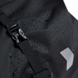 A black waterproof duffle bag with a buckle closure, featuring a textured surface and droplets of water.