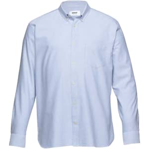 A light blue button-up shirt with a collar and a front pocket, featuring a logo on the label.