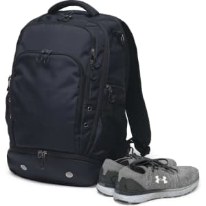 A navy backpack with multiple pockets, accompanied by a pair of grey sports shoes. The bag has a logo.