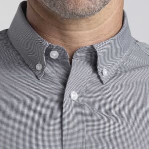 A close-up of a men's button-up shirt featuring a grey checked pattern and a button-down collar. Includes branding.